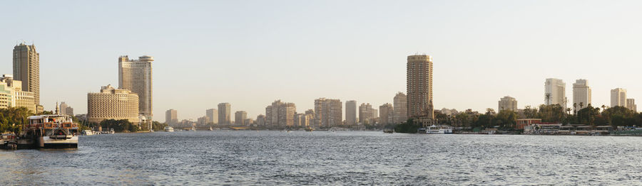 City at waterfront against clear sky