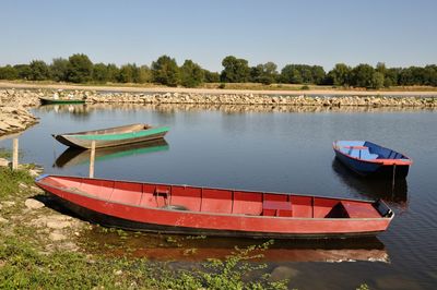 Boat moored in lake against sky