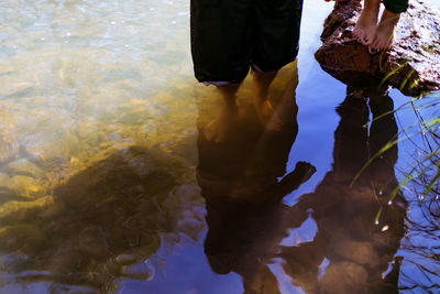 Low section of man standing in puddle