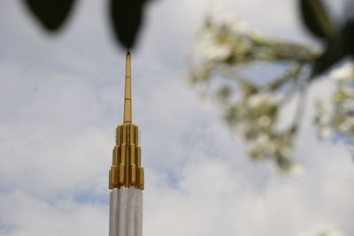 Low angle view of cross tower against sky