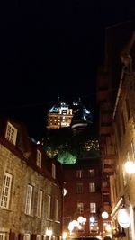 Low angle view of illuminated buildings against sky at night