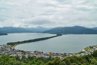 High angle view of townscape by lake against sky