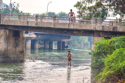 Man standing on bridge over river