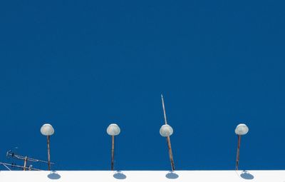Low angle view of communications tower against clear blue sky
