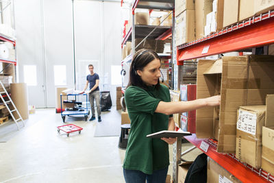 Male and female colleagues examining boxes in industry