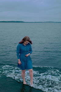 Young girl on a background of the sea in a blue dress, portrait