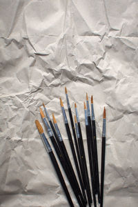 High angle view of paintbrushes on paper