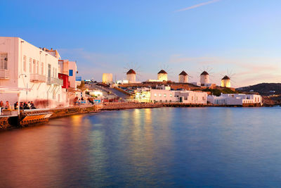 Buildings by sea against sky in city