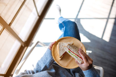 Midsection of woman holding sandwiches in plate