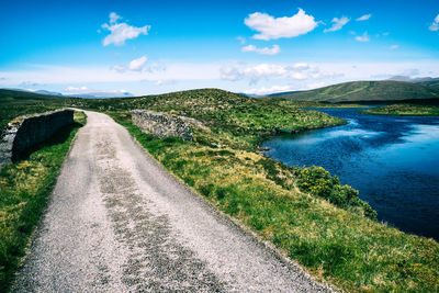 Small stone bridge over a lake with a small boat on the shore in the empty highlands of scotland