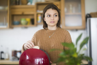 Young woman cleaning dishes in the kitchen