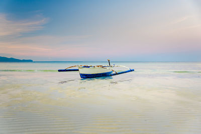 Small boat at the shore of boracay, philippines during early morning low tide.