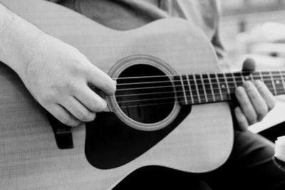 Midsection of man playing guitar