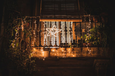 Illuminated building by lake seen through window