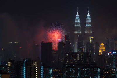 Illuminated petronas towers and fireworks at night