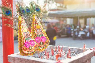 Peacock feathers and religious offerings outside temple