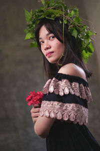 Portrait of woman standing by flower plant