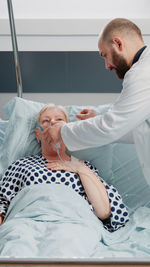 Side view of doctor examining patient at clinic