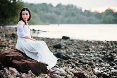 Woman sitting on rock at beach