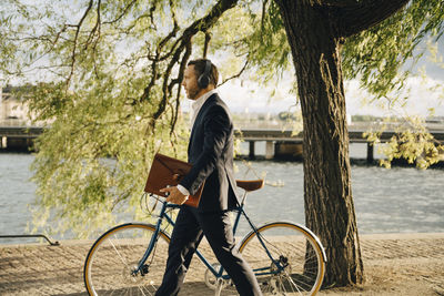 Woman riding bicycle by river in city