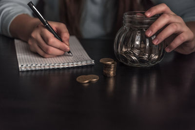 Midsection of man holding cigarette on table