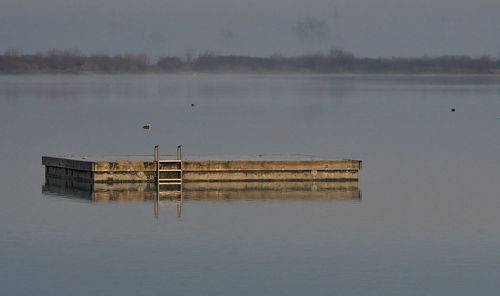 Lifeguard hut in lake against sky