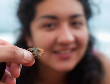 Cropped hand showing crab to woman