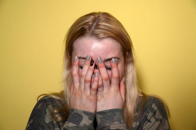 Close-up of woman with hands covering face