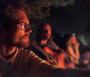 Portrait of young man using smart phone at night