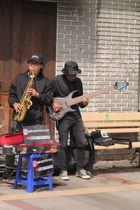 Two street musicians playing on the sidewalk  