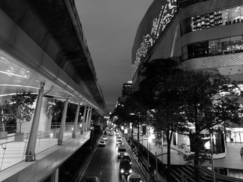 Cars on road amidst illuminated city at night