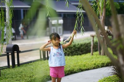 Full length of girl with plants in foreground