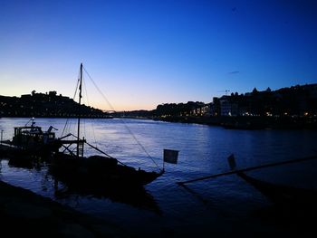 Boats sailing in river at sunset