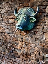 Close-up of statue against brick wall