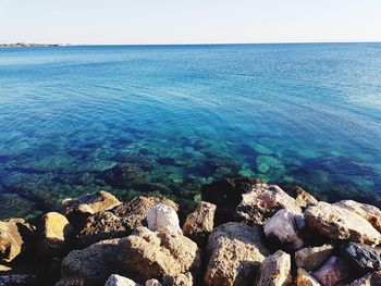 Rocks by sea against sky