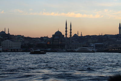 View of canal and buildings against sky during sunset