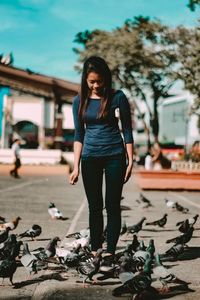 Portrait of young woman standing against sky