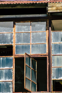 Low angle view of rusted window of abandoned building