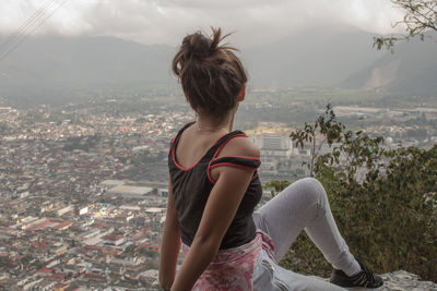 Rear view of young woman against sky