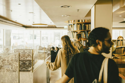 Rear view of man and woman reading book