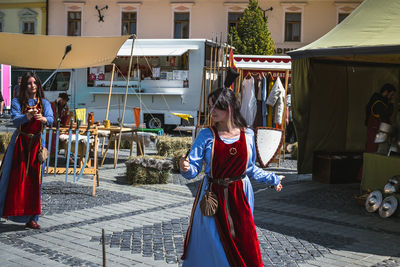 Woman standing on street against buildings in city