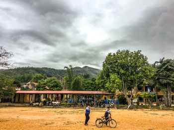 Man riding bicycle on mountain against sky