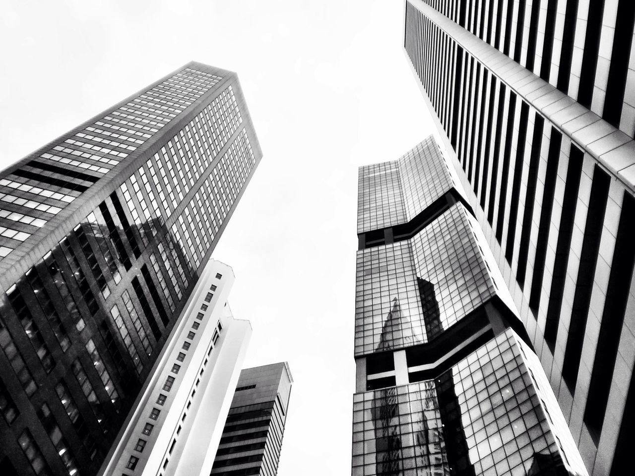 skyscraper, building exterior, architecture, modern, built structure, office building, tall - high, low angle view, city, tower, building, tall, clear sky, sky, glass - material, financial district, city life, reflection, day, development