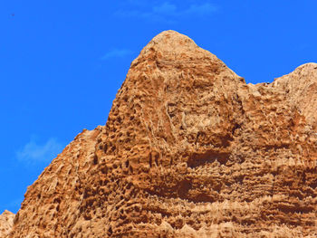 Low angle view of landscape against clear blue sky