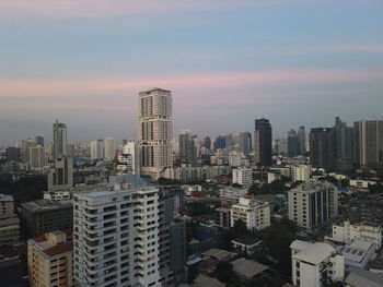 Modern buildings in city against sky during sunset