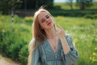 Portrait of young woman standing against plants