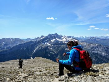 People sitting on mountain road against sky