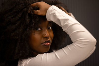 Rear view of young woman standing against wall