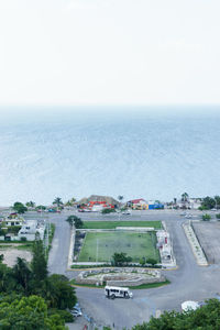 High angle view of city by sea against clear sky