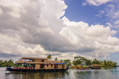 Boathouses in backwaters against cloudy sky